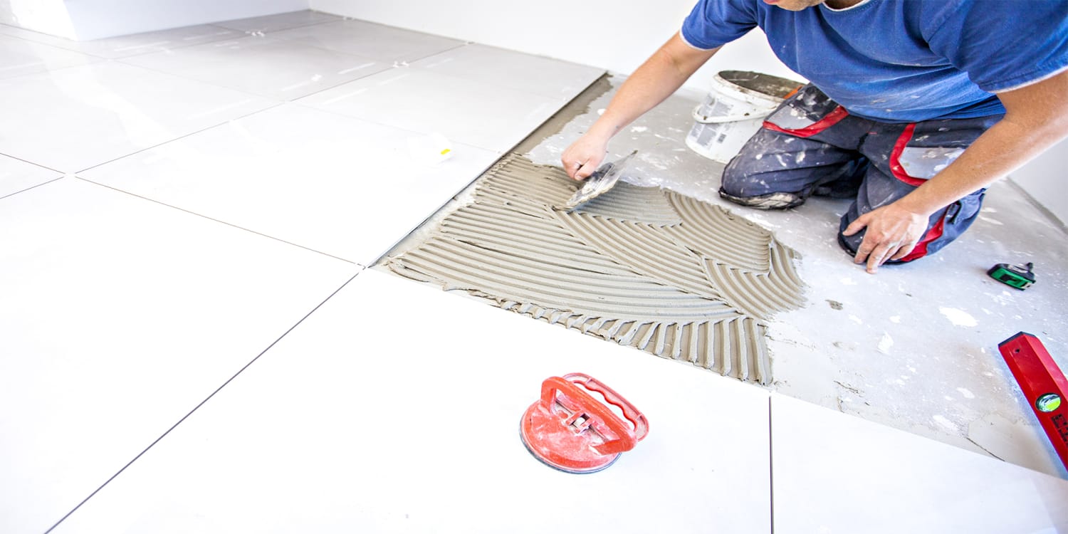 House flipper retiling floor during renovation